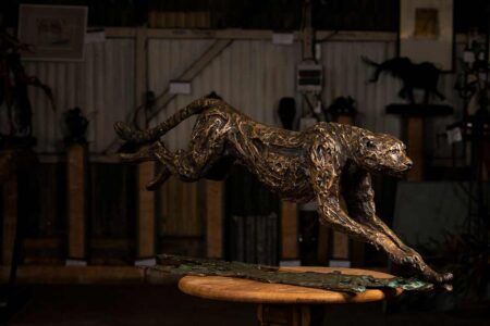 Bronze sculpture of a cheetah in flight